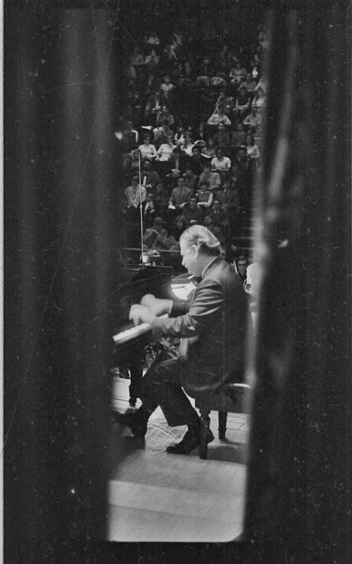 Pianist Eugene List performing with the student orchestra, here seen from the wings.