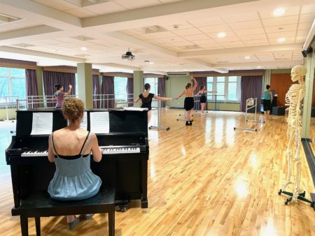 Pianist playing for dance students in dance studio setting